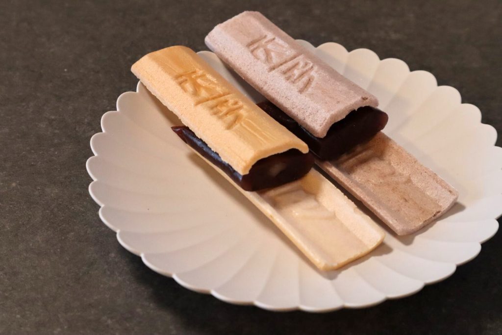 最中の皮に粒あんを挟んで完成させる様子、断面写真